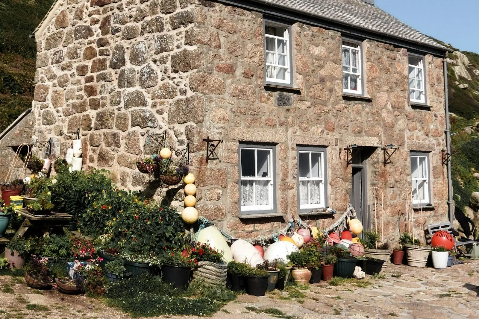 Gull Cottage, a granite cottage with a front garden full of fishing floats